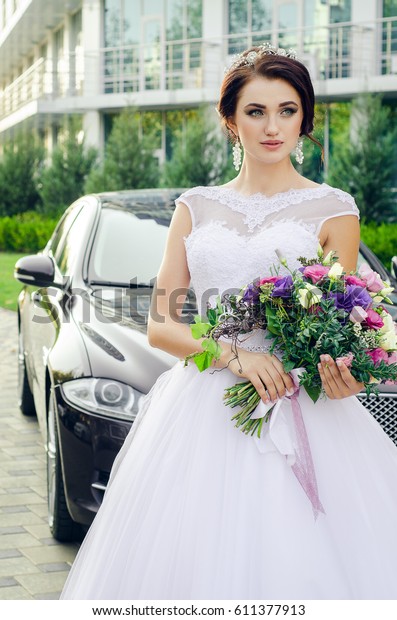girl in\
wedding dress with flowers near the\
car