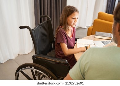 Girl In A Wheelchair Is Studying With An Adult Male