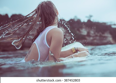 girl in a white bathing suit in the water . beautiful girl in the ocean surf . Girl in the ocean poses on longboards. Surf Girl in the rain.
a girl with a good figure and a beautiful body in water.