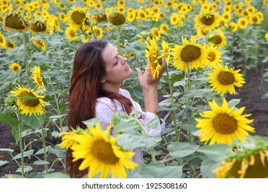 Mädchen in einem weißen Kleid unter blühenden Sonnenblumen