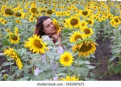 Mädchen in einem weißen Kleid auf einem Feld mit Sonnenblumen