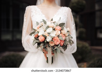 a girl in a white dress holds a wedding bouquet in her hands close-up - Powered by Shutterstock