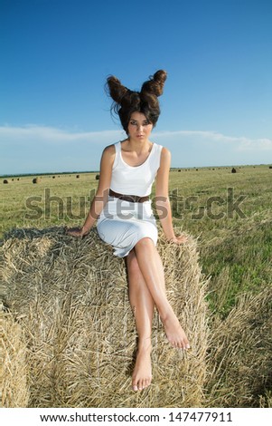 Girl in white dress and interesting hairstyle in countryside, summer shoot