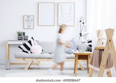 Girl In White Dress Walking Around Modern Cozy Room With Coat Rack