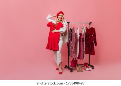 Girl in white jacket and beautiful designer trousers with red beret on her head trying on new dress - Powered by Shutterstock