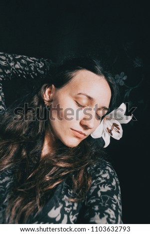 a girl with a white lily and closed eyes