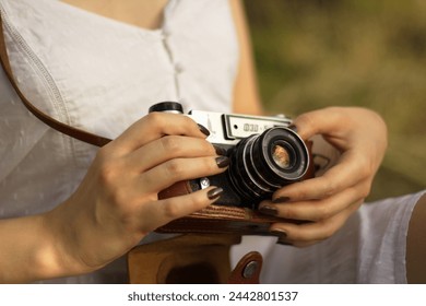 A girl in a white shirt has an old camera - Powered by Shutterstock