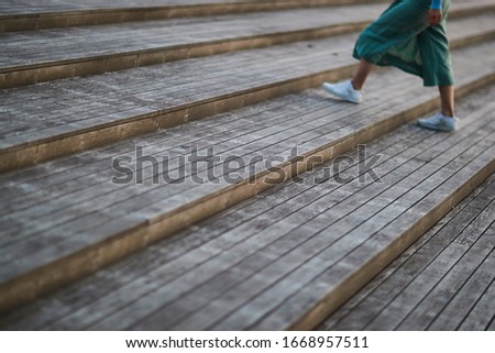 girl in white sneakers and pants walking on the stairs