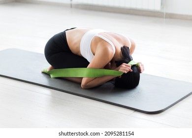 A Girl In A White Top And Black Cycling Shorts Posing In A Fetal Position Pulling On A Gymnastic Ribbon. Horizontal Photo