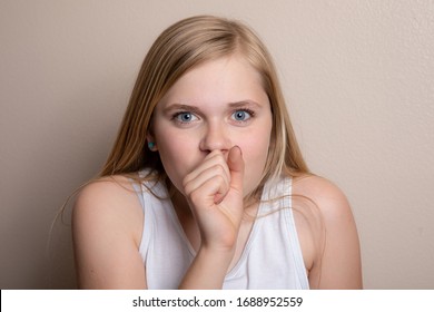 girl who can be sick or with allergies is coughing into her hand