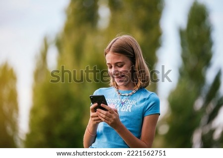 Similar – Teenager lächelnd, der sein Smartphone auf einem Basketballplatz aussieht.