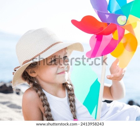 Girl with windmill on sea in summer