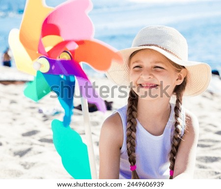 Girl with windmill on sea in summer
