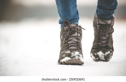 girl in winter boots walking on snowy road