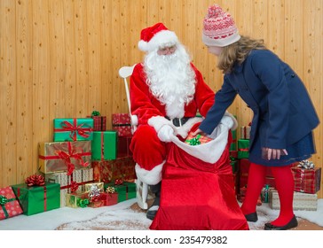 A Girl In Winter Clothing Visiting Santa In His Grotto