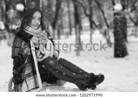 A girl in a winter cloudy day of snow-covered fields and forests

