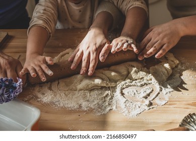 girl and woman cook at home. in a kitchen, a child, mom, dad stirs flour, knead the dough on the table by hand. baby help mom.
