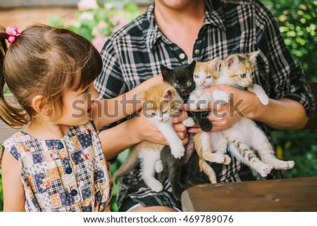 girl and woman playing with kittens.