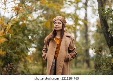 A Girl In A Woolen Coat Walks In A Beautiful Autumn Park.