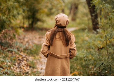 A Girl In A Woolen Coat Walks In A Beautiful Autumn Park.