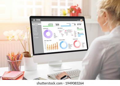 Mädchen arbeitet mit Desktop-Computer im Büro. Anzeige verschiedener Diagramme, Grafiken und Infografiken von CRM auf dem Computerbildschirm.