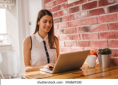 Girl working on laptop in cozy apartment