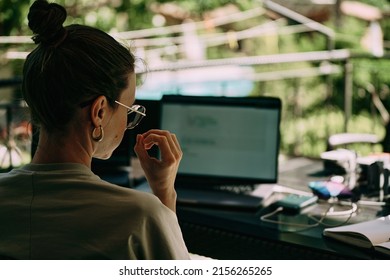 A Girl Working On The Table On The Terrace. Many Laptops And Other Staff. Back View. High Quality Photo