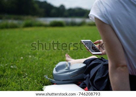 girl is working with phone on the grass