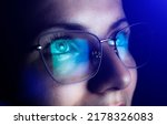 Girl works on internet. Reflection at the glasses from laptop.Close up of woman