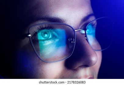Girl works on internet. Reflection at the glasses from laptop.Close up of woman's eyes with black female glasses for working at a computer. Eye protection from blue light and rays.