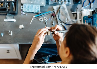 The Girl Works On A Jewelry In The Workshop