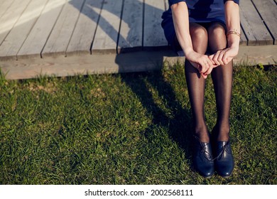 The Girl Wrapped Her Arms Around Her Legs. Grass.