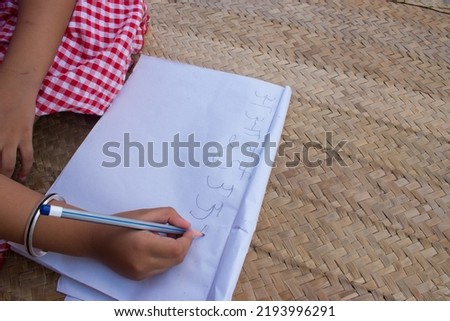 Girl writing hindi alphabets on paper. 14 September Happy Hindi Diwas or Hindi Language Day. selective focus on subject.
