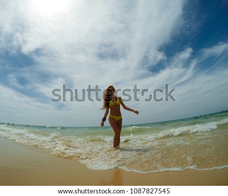 Girl in yellow bikini on the ocean coast 