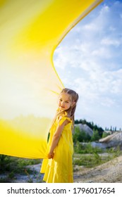 Girl In A Yellow Dress With Wings In A Yellow Cloth Near The Lake