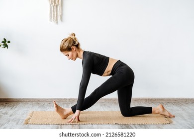 A girl, a yoga instructor, in a black suit, is doing yoga.girl stands in the position of a triangle. Tuning the pose of ardha trikonasana.calm your soul. High quality photo