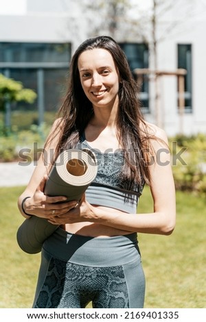 Girl with yoga mat before starting workout practice outdoors. Sport, healthy lifestyle, yoga meditation concept.