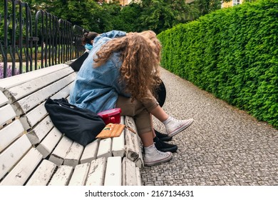 Girlfriend comforts her friend hugging her on a white wooden bench in a city park. Problems of youth, consolation and help in difficult times - Powered by Shutterstock