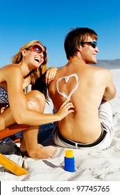 Girlfriend Playfully Draws A Heart On Her Boyfriends Back With Spf Suncream To Protect Him From The Harsh Sun While On Their Tropical Summer Beach Vacation