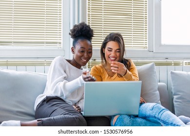 Girlfriend watching a very funny movie on laptop. Smiling young women relaxing and watching movies at home, female friends having rest after hard week, copy space - Shutterstock ID 1530576956
