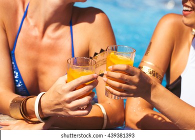 Girlfriends Clinking Glasses With Cocktails At The Poolside Bar. Summer Time