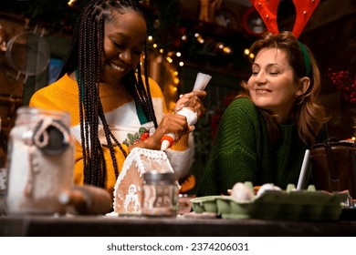 Girlfriends Decorating gingerbread house for sale at Christmas market - Powered by Shutterstock