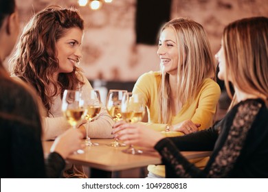 Girlfriends Drinking Wine And Chatting While Sitting In The Bar.