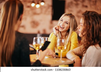 Girlfriends Drinking Wine And Chatting While Sitting In The Bar.