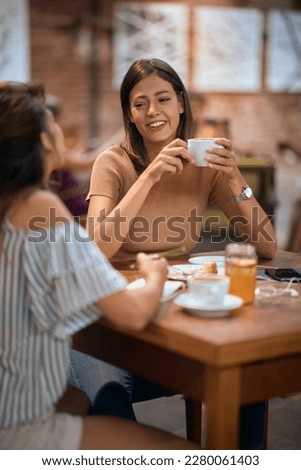 Girlfriends having coffee together. Young women enjoying their time in cafe restaurant, having a conversation. 