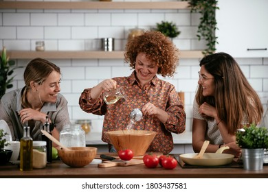 Girlfriends Having Fun In Kitchen. Sisters Cooking Together.	