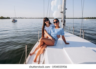 Girlfriends relaxing on the yacht. Two girls celebrating a birthday on the yacht. Evening walk on the yacht on the sea.