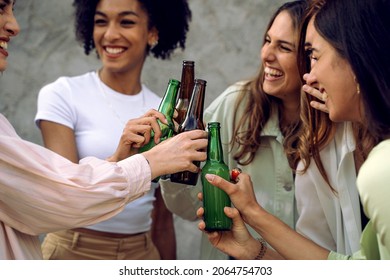 Girlfriends Toast Beer Bottles - Concept Of Carefree And Togetherness - Women Only - Focus On The Hand Holding The Bottle