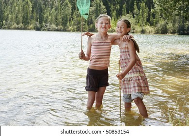 Girls (7-9) Standing Knee-deep In Lake, Playing.