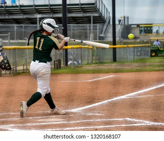 Girls In Action Playing In A Softball Game